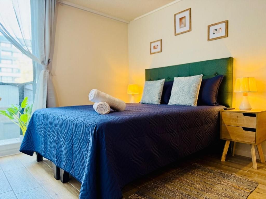 Una habitación de hotel con una cama, mesitas de noche y un ventanal.