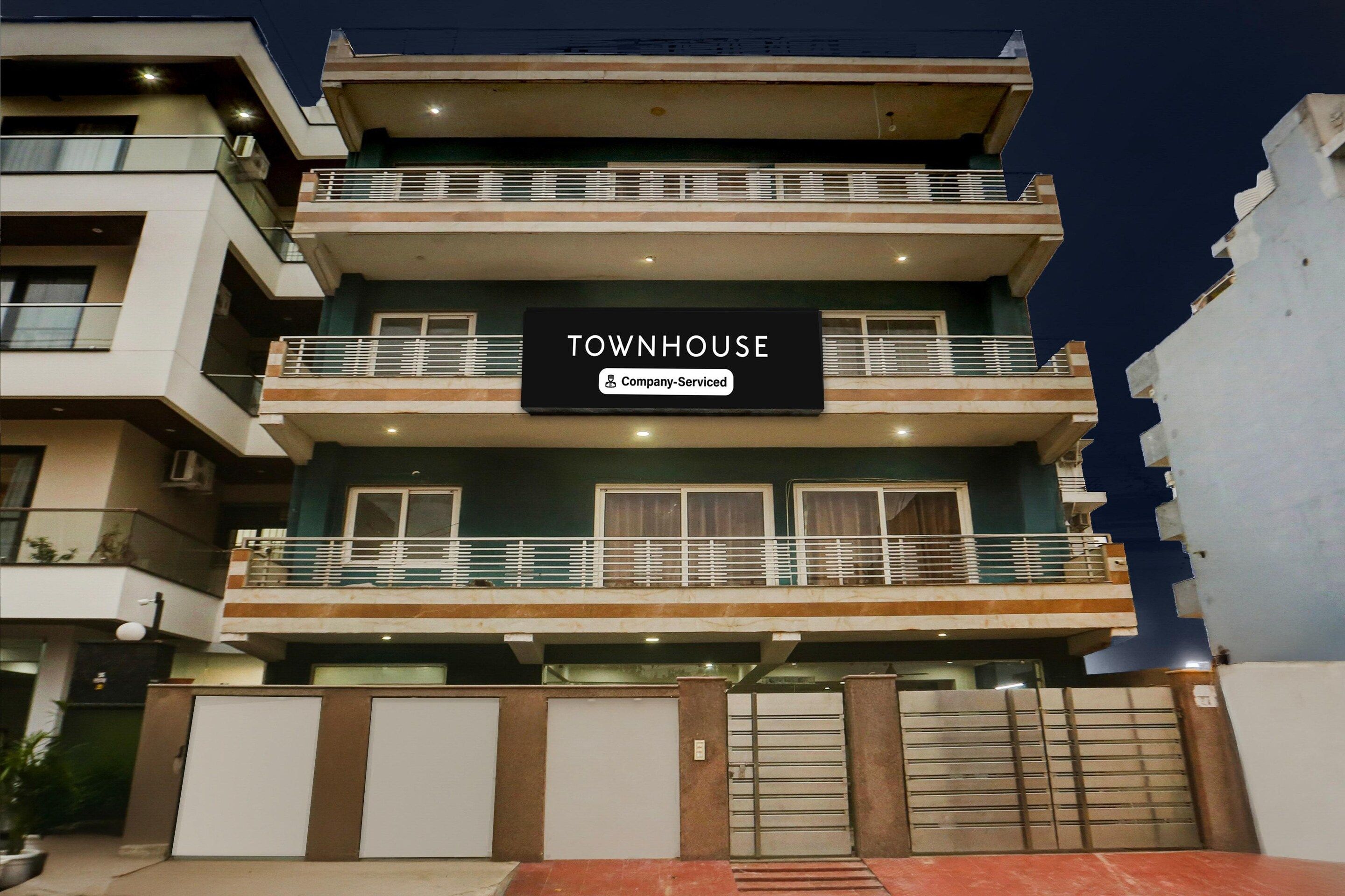 A multi-story building with a sign indicating it is a company-serviced townhouse.