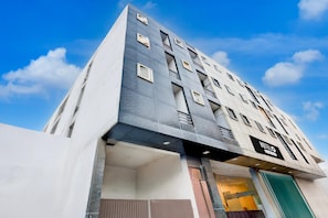 A modern hotel with a unique architectural design, featuring multiple balconies and a prominent entrance. - Hotel O Rangpuri Mahipalpur (New Delhi)