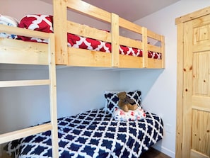 A bunk bed with a patterned bedspread and a teddy bear on the lower bunk. - Boat Launch Access | FirePit | 30MI to YNP (Island Park)