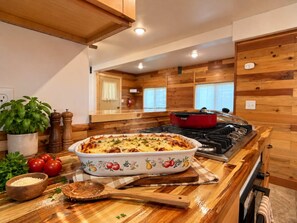 A kitchen with a stove, a casserole dish on the counter, and a potted plant. - Boat Launch Access | FirePit | 30MI to YNP (Island Park)
