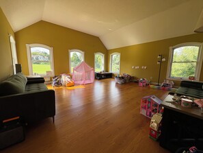 A spacious living room with a high ceiling, large windows, and a play area with a pink tent. - New Milford Oasis - 4 bedrooms 5 1/2 baths (New Milford)