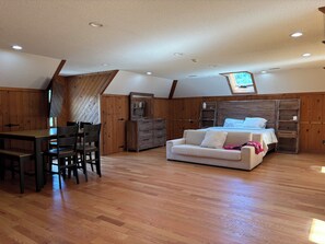 Ein Schlafzimmer mit einem Bett, einem Schlafsofa, einem Schreibtisch und einem Sessel.