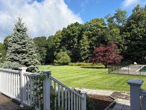 A well-maintained lawn with a white fence and a tree with red leaves. - New Milford Oasis - 4 bedrooms 5 1/2 baths (New Milford)