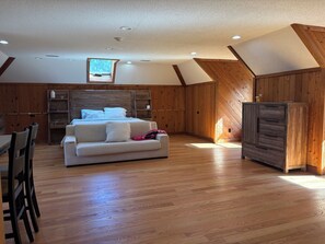 A bedroom with a wooden ceiling, a bed, a nightstand, a dresser, and a window. - New Milford Oasis - 4 bedrooms 5 1/2 baths (New Milford)
