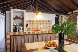 A kitchen with a tiled backsplash, wooden cabinets, a sink, and a fruit bowl on the counter. - Las Ninfas Natural Escape 4 (Icod de los Vinos)