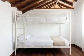 A bunk bed with white bedding and a wooden ceiling. - Las Ninfas Natural Escape 4 (Icod de los Vinos)