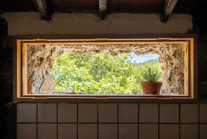 A window with a stone frame and a view of greenery outside. - Las Ninfas Natural Escape 3 (Icod de los Vinos)