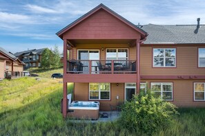 A two-story building with a balcony, a hot tub, and a view of surrounding houses. - Downtown WP Chalet 380 I Private Hot Tub I Great Views I Bunk Room I Discounted Attractions (Fraser)