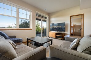 Ein Wohnzimmer mit einer Couch, einem Couchtisch und einem Fernseher auf einem Lowboard.