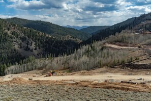 Eine Baustelle mit schwerem Gerät und einer hügeligen Landschaft.