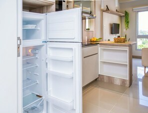 A modern kitchen with a built-in refrigerator, a wooden countertop, and a small island with a basket. - Cozy apt relaxing view - Great Guest Service 604 (Fernando de la Mora)