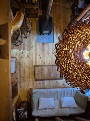 A wooden floor with a sofa and a hanging light fixture.