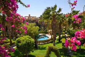 Una piscina circondata da lussureggiante vegetazione e palme.