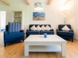 A living room with three sofas, a coffee table, and a painting on the wall. - Holiday Apartment 3 "norderoog" (Tating)