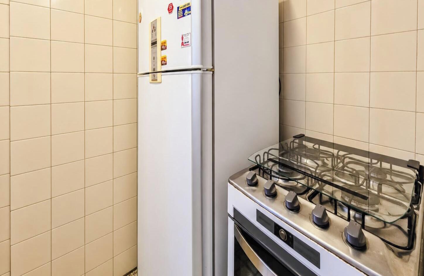 A kitchen with a gas stove and a refrigerator.