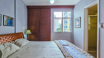 Un dormitorio con cama, ventana, puerta y ventilador de techo.