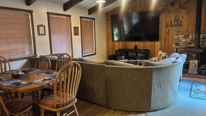 A cozy living room with a sectional sofa, a flat-screen TV, and a fireplace. - 6 Bedroom Downtown Lodge w/ Game Room, BBQ, Deck (Gold Coast)
