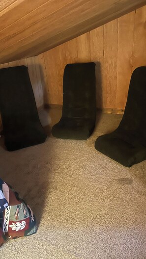 A room with a wooden ceiling and three black chairs against a wall. - 6 Bedroom Downtown Lodge w/ Game Room, BBQ, Deck (Gold Coast)