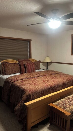 A bedroom with a bed, a nightstand, a lamp, a ceiling fan, and a window with blinds. - 6 Bedroom Downtown Lodge w/ Game Room, BBQ, Deck (Gold Coast)
