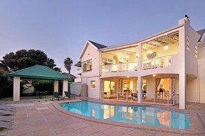 A two-story house with a swimming pool, outdoor seating, and a covered patio. - Walking distance to Camps Bay Beach, Views - Merridew (Cape Town)