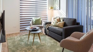 Een woonkamer met een bank, fauteuil en een salontafel.