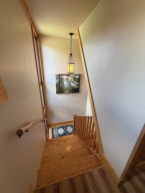 A wooden staircase with a wooden handrail and a wooden floor.