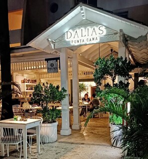 Ein Restaurant namens 'DALIAS PUNTA CANA' mit Außenbereich und Blumentöpfen.