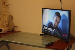 A television on a glass table displaying the Netflix show 'El Justicero 2'. - Residencial Alborada: Relaxation with a Caribbean Spirit (Puerto Morelos)