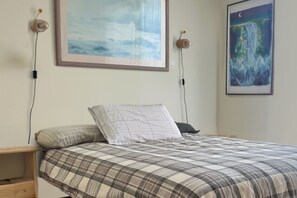 A bedroom with a bed, a nightstand, a wall-mounted lamp, and two framed artworks. - 8 minutes to the Peninsula Hot Spring! Family, couples, workers retreat in Rye (Rye)