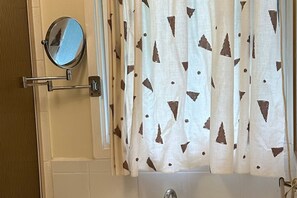 A bathroom with a white bathtub, a round mirror, and a curtain with a geometric pattern. - 8 minutes to the Peninsula Hot Spring! Family, couples, workers retreat in Rye (Rye)