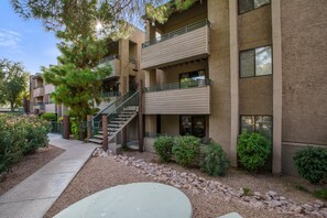 A multi-story building with a central staircase, outdoor seating area, and landscaped garden. - Old Town Scottsdale Oasis&Heated Pools&Golf&Gym (Scottsdale)