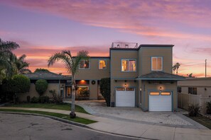 A two-story house with a garage, a driveway, and a well-maintained lawn.