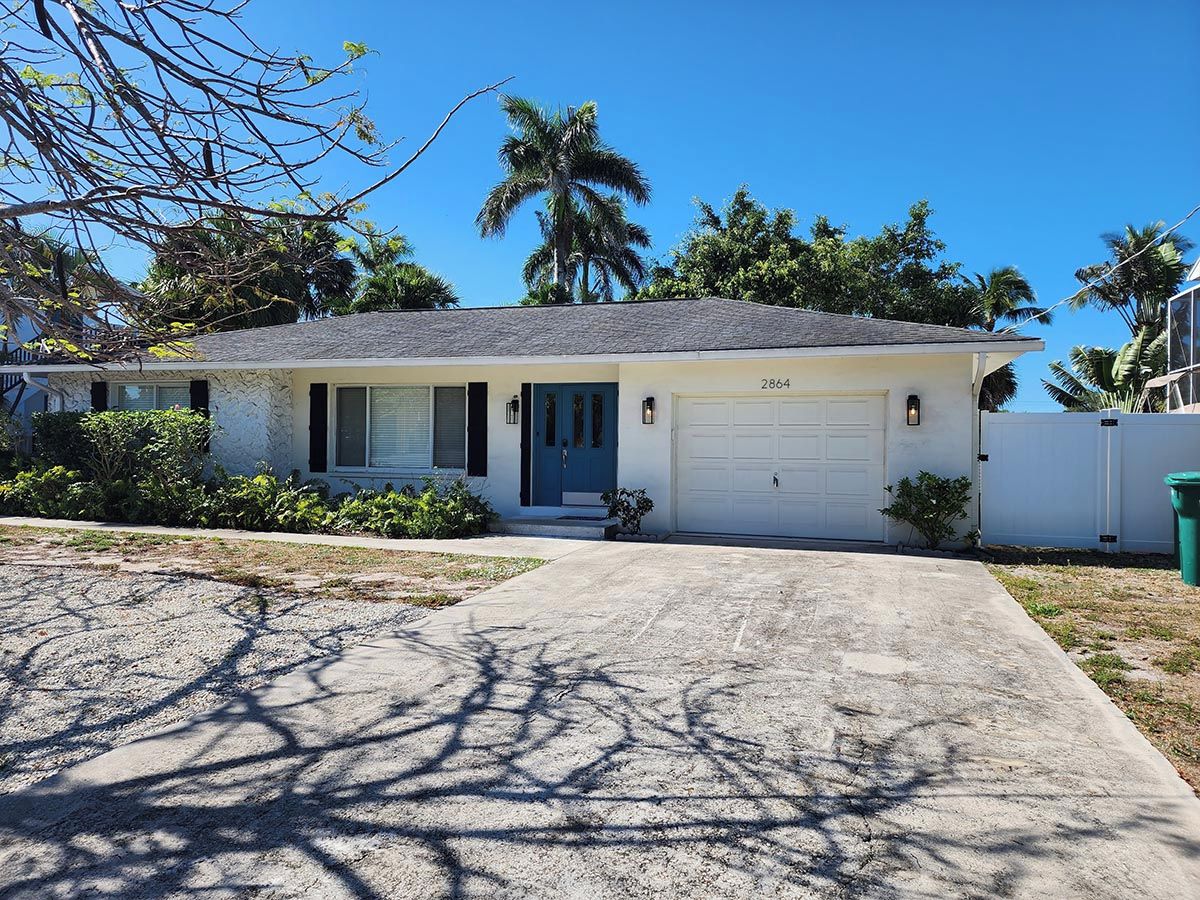 A single-story house with a garage, a front porch, and a driveway.