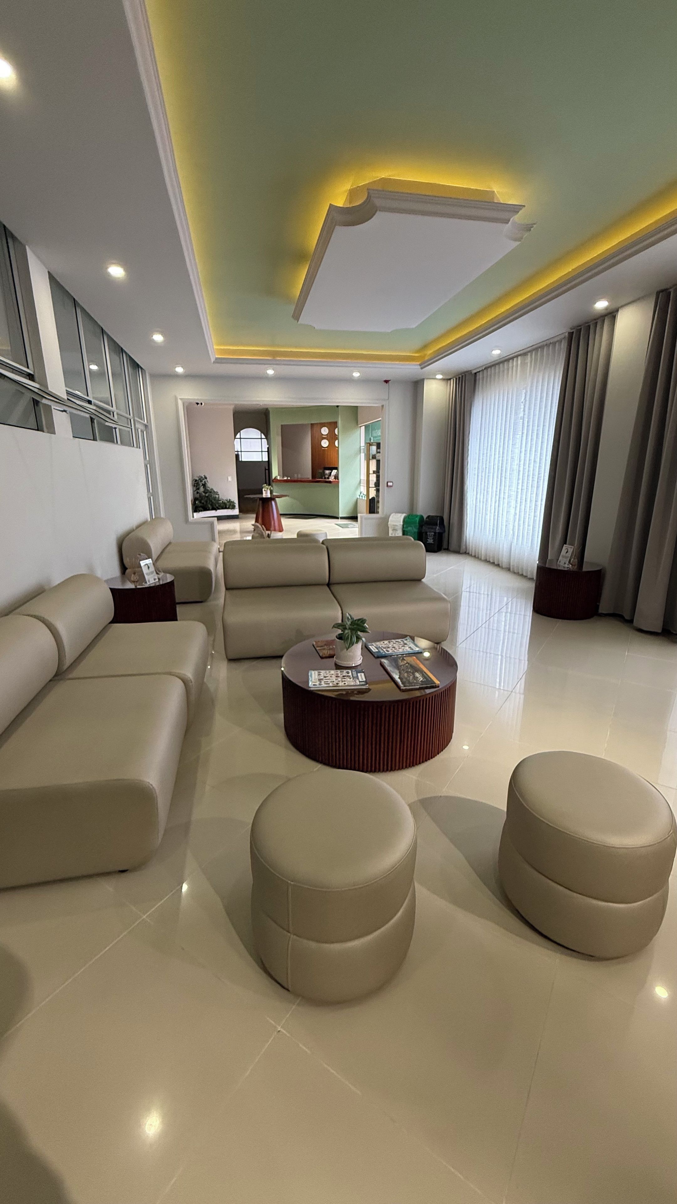 Ein modernes Wohnzimmer mit einem Ecksofa, einem runden Couchtisch und einem Essbereich im Hintergrund.