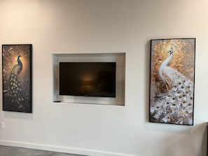 A wall with three framed artworks and a flat-screen TV. - Wine Down in Blanco — Two King Master Suites & Hill Country Luxury (Blanco)