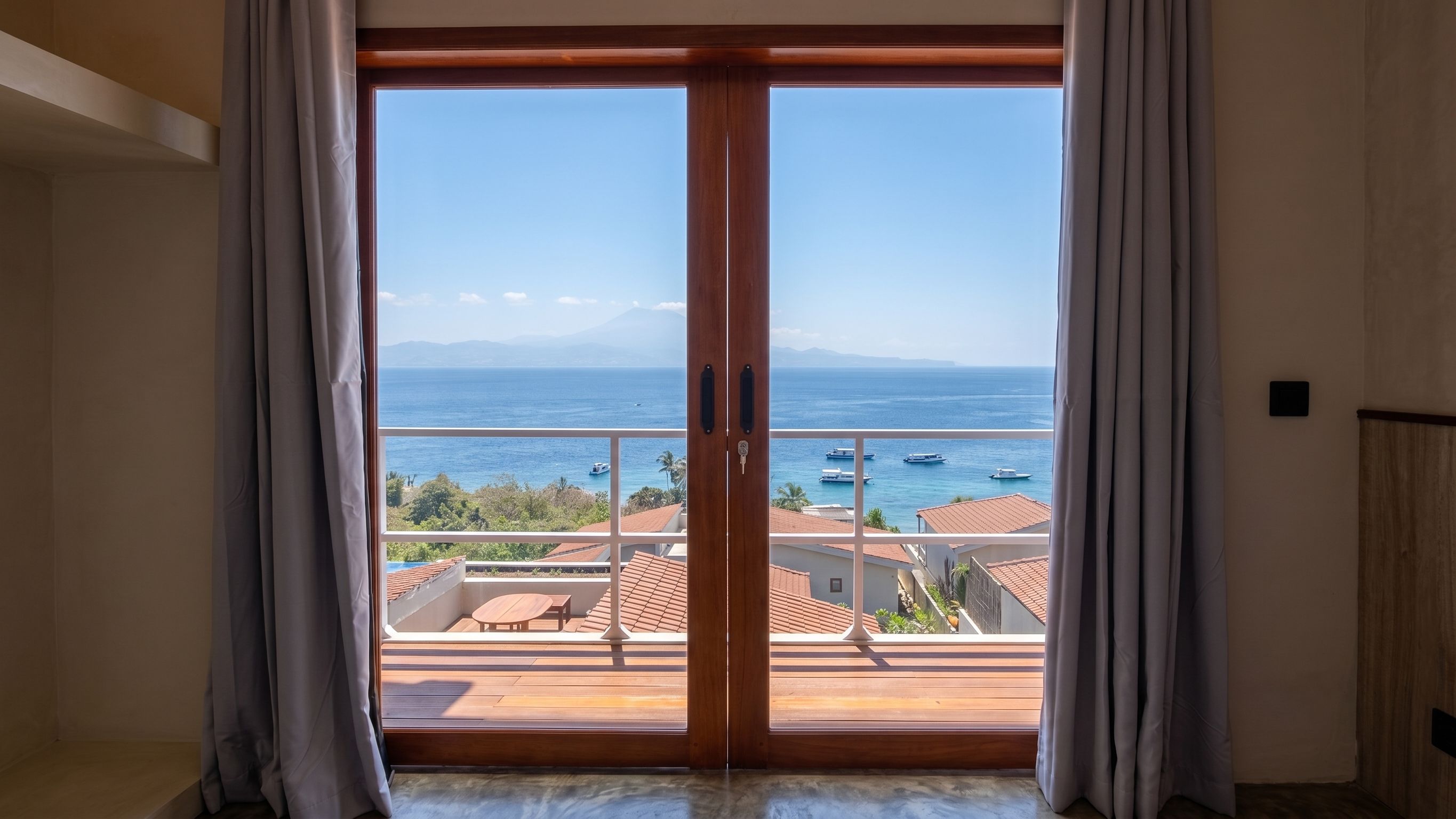 A room with a view of the sea through a wooden door with a keyhole.