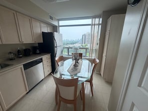 A modern kitchen with a dining area, large windows, and a view of the cityscape. - Cozy 2Bed 2Bath-CN Tower view- Yonge & Sheppard (Toronto)