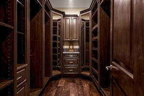 A walk-in closet with wooden doors, drawers, and shelves. - Mediterranean Beverly Hills estate w/pool, spa & fire pit, sleeps 14 (Beverly Hills)