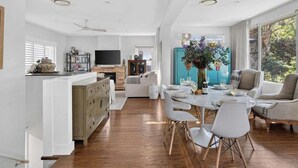Una cocina moderna con comedor, suelo de madera y un gran ventanal que proporciona luz natural.
