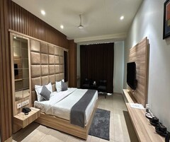 Quarto moderno com cama grande, guarda-roupa embutido e televisão na parede.