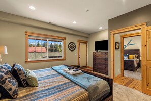 A bedroom with a bed, dresser, and a television. - Downtown Leavenworth 2BR/2BA condo with fireplace, deck, parking. (Leavenworth)
