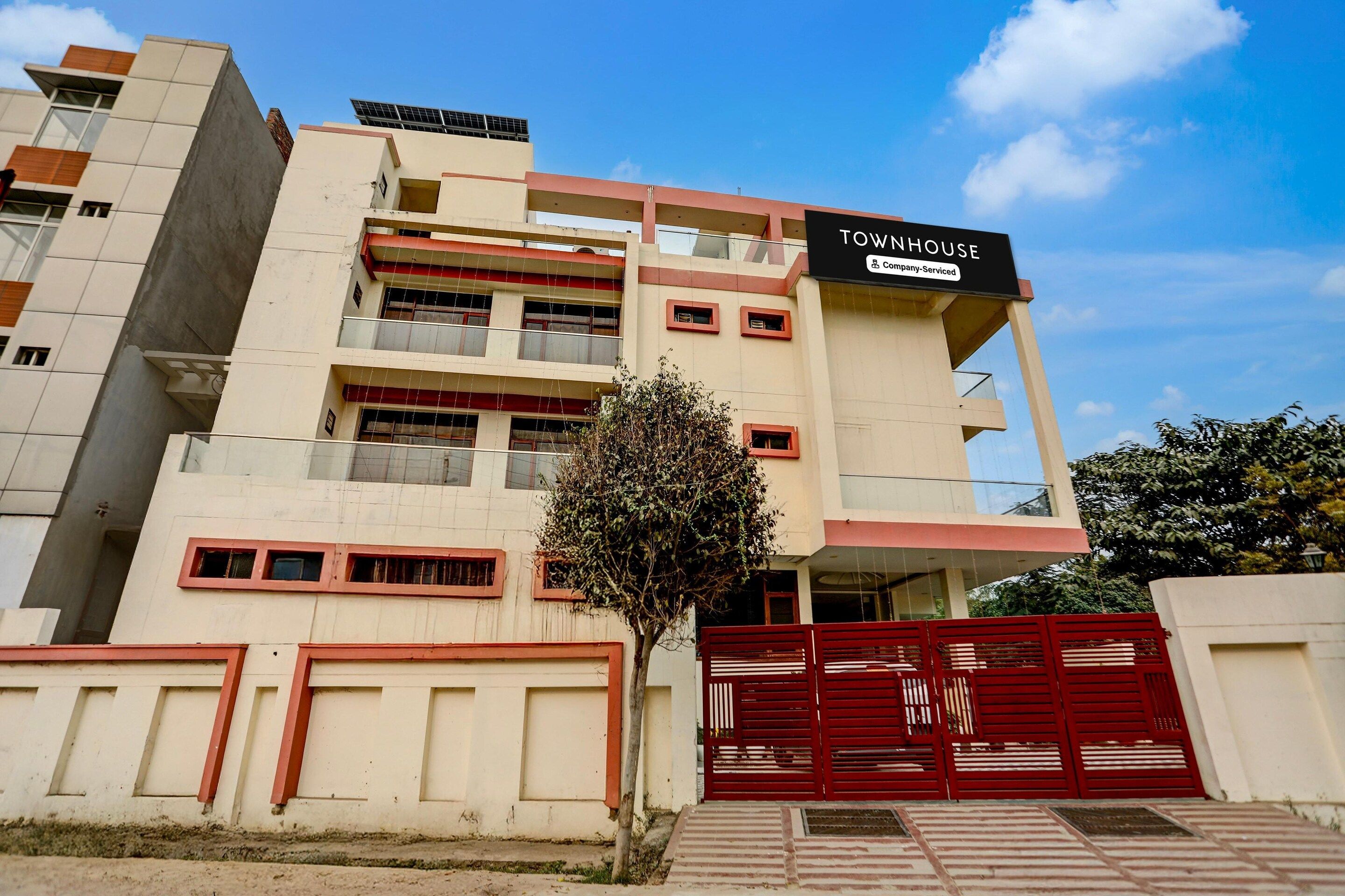 Un edificio de varios pisos con un letrero que indica que es una casa adosada con servicios de empresa.