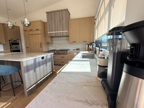 Eine moderne Küche mit einer zentralen Kochinsel, Edelstahlgeräten und Holzschränken.