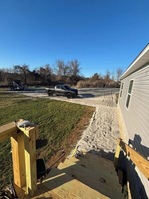 A wooden deck with a workbench, a trailer, and a truck parked in a yard with a house in the background. - 5-bdr 3 bath fully furnished house in Burnside Ky minutes from Lake Cumberland (Burnside)