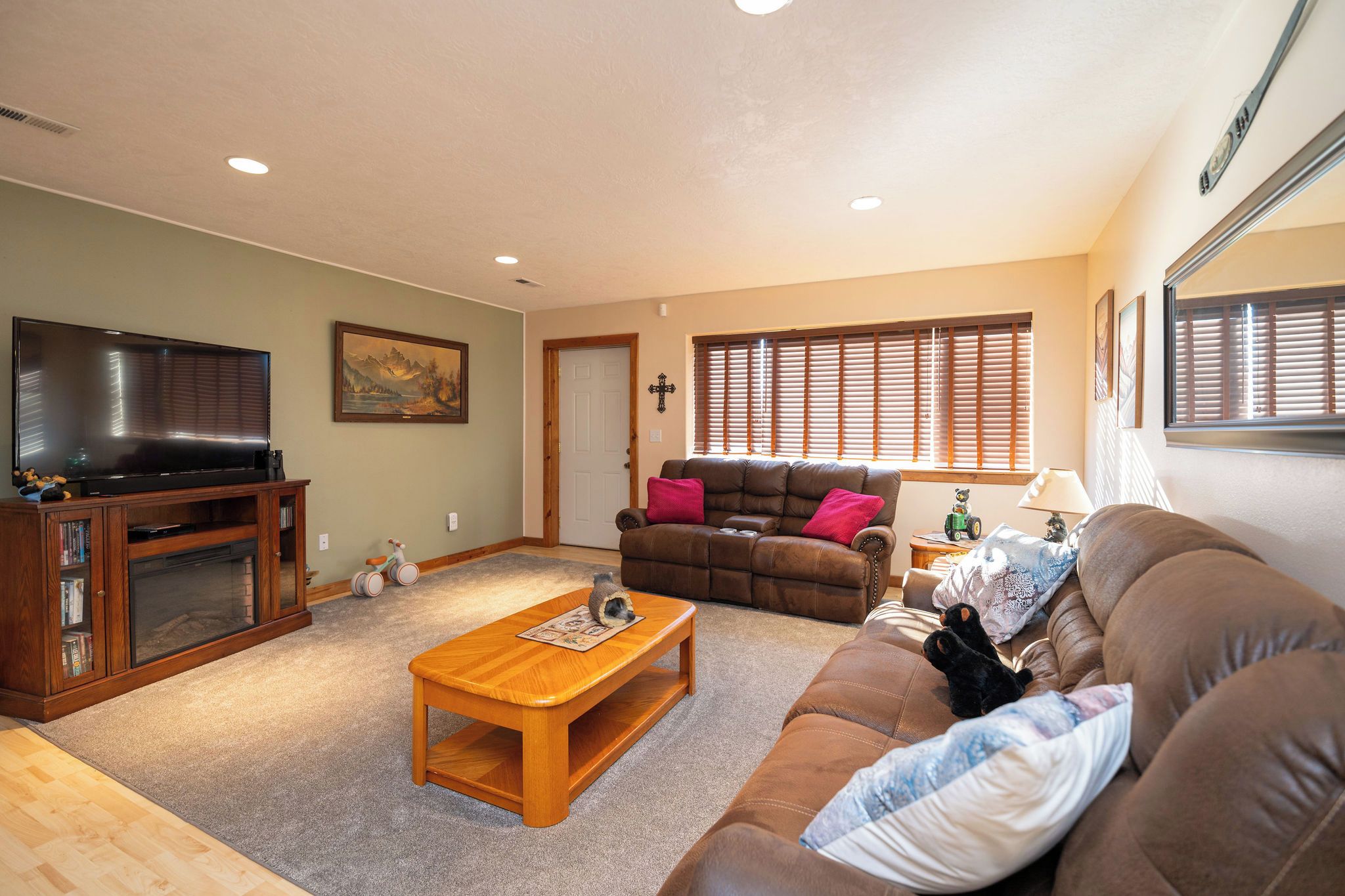 A living room with a television, sofa, coffee table, and a fireplace.