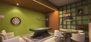 A room with a dartboard, billiards table, and a billiard table with chairs.