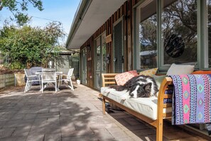 A cozy outdoor seating area with a sofa, a table, and chairs. - Harbour Grove Blairgowrie Coastal Sanctuary (Blairgowrie)