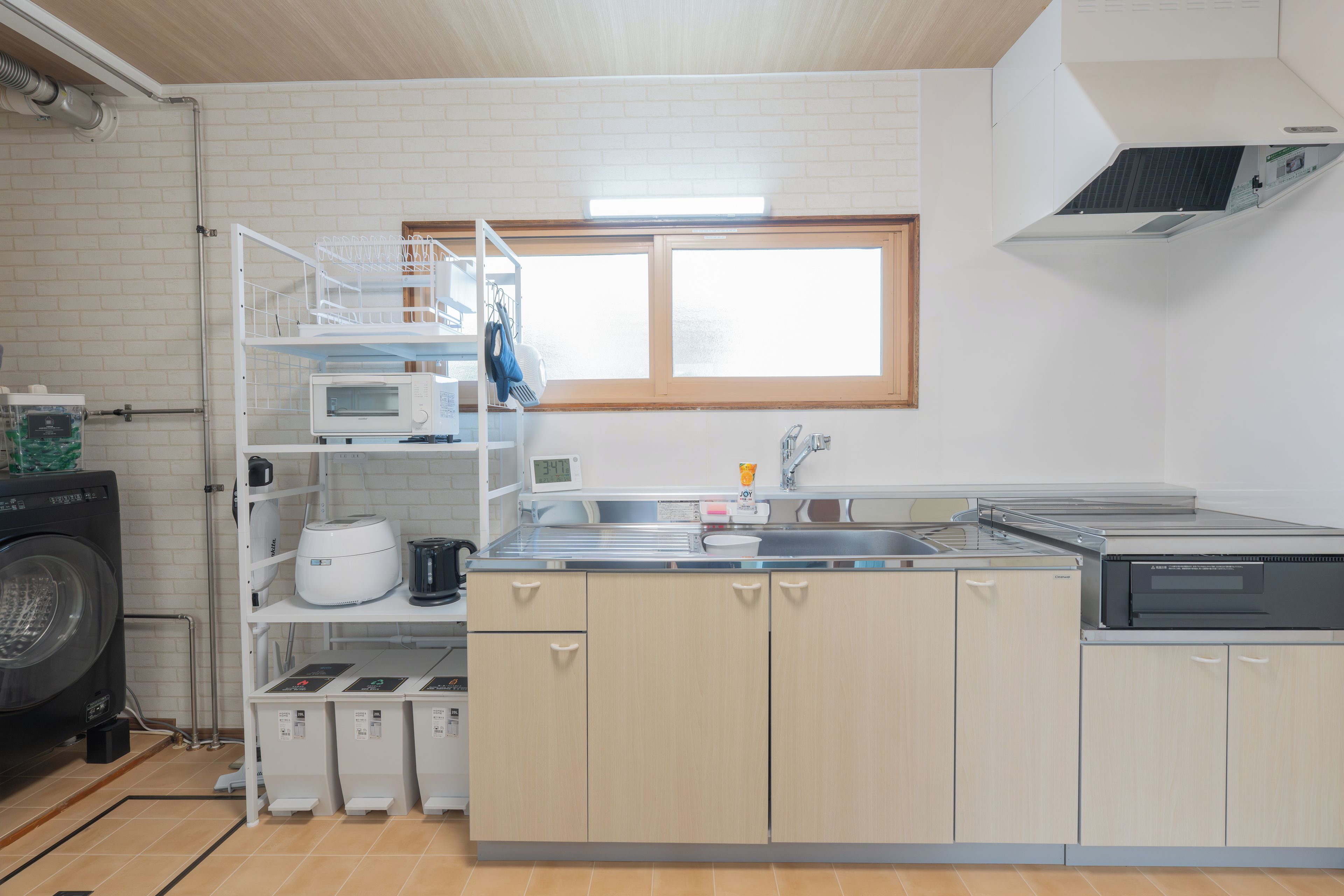 A compact kitchen with a built-in washing machine, a microwave, and a sink.