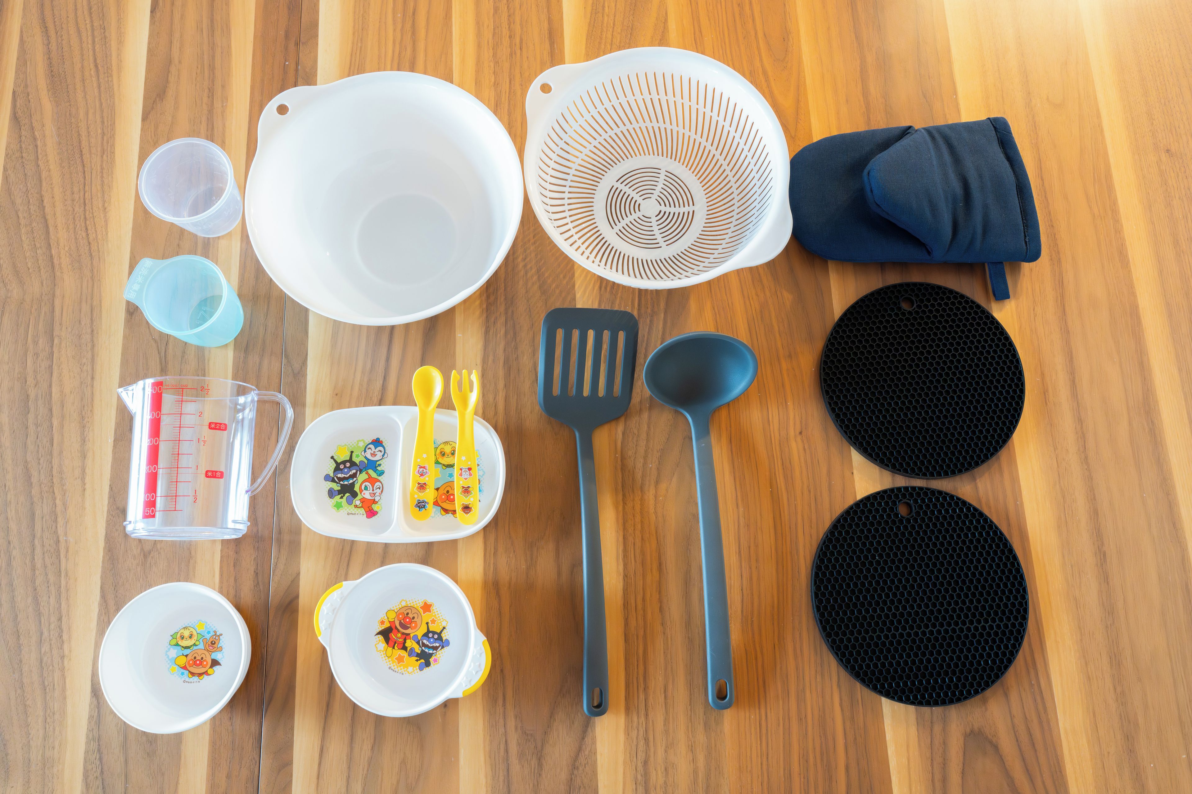 Diversos utensílios de cozinha e louças dispostos sobre uma superfície de madeira.